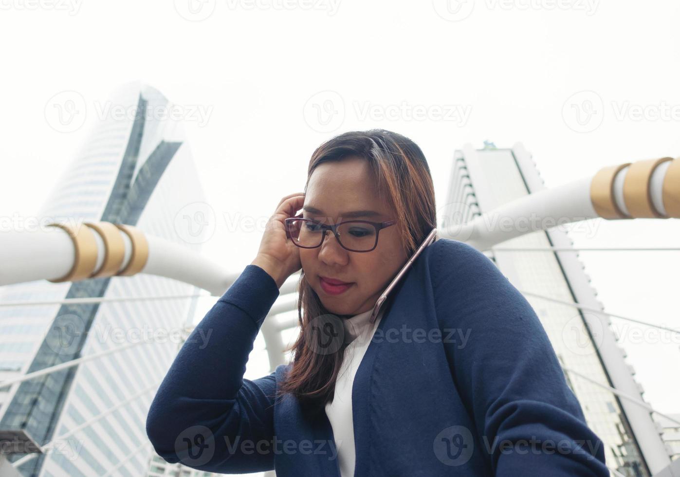 Frau geht im Freien spazieren und telefoniert mit dem Handy foto