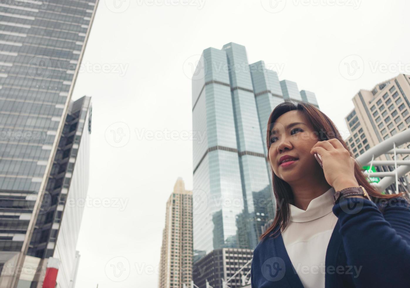 Frau geht im Freien spazieren und telefoniert mit dem Handy foto