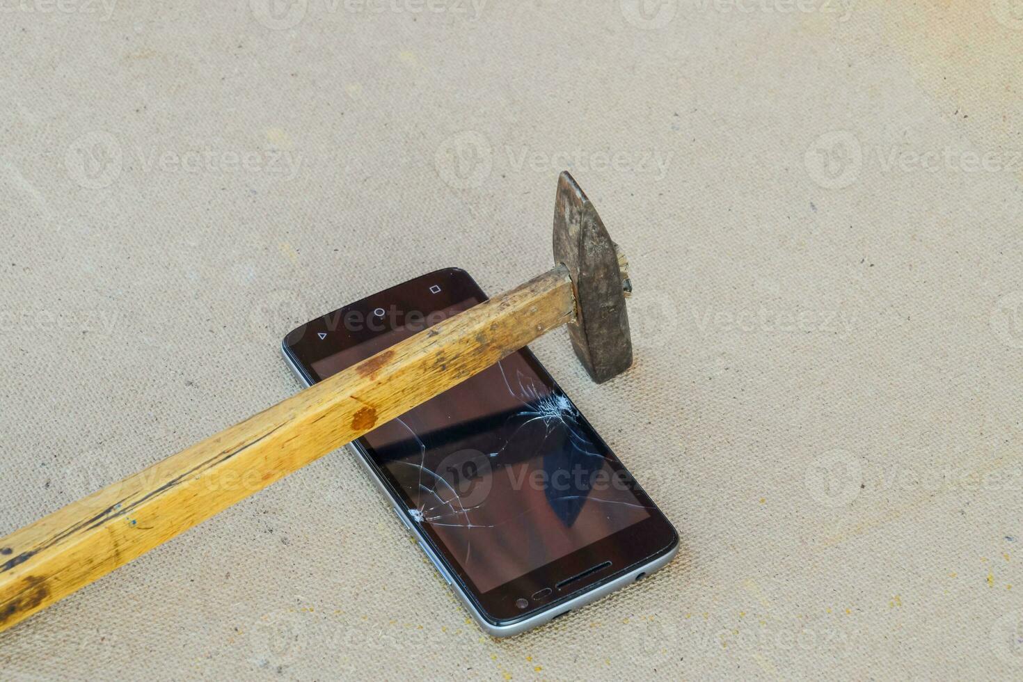 Hammer und Smartphone. das Bildschirm von das Smartphone, ein gebrochen Ha foto