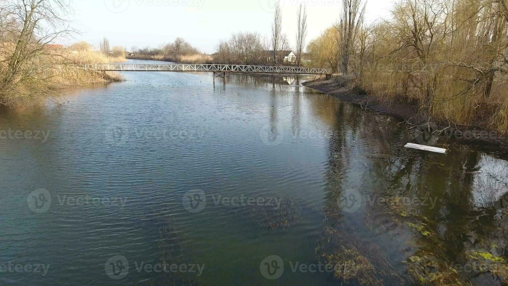 Fluss erik Strom im das Dorf im das Frühling. flach Fluss, langsam fließend im das Dorf. foto