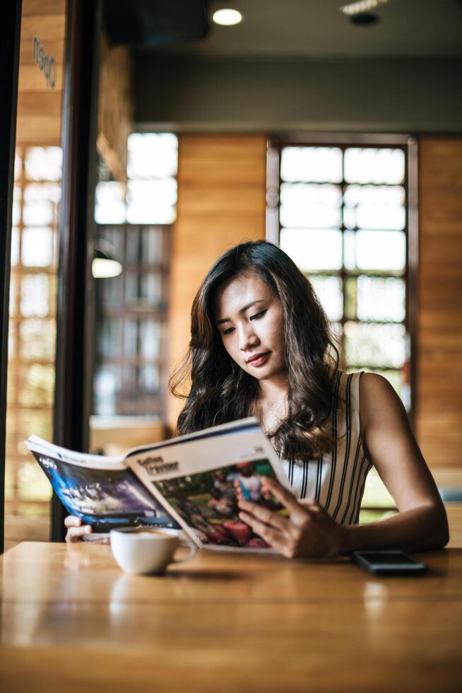 schöne Frau liest Zeitschrift im Café? foto