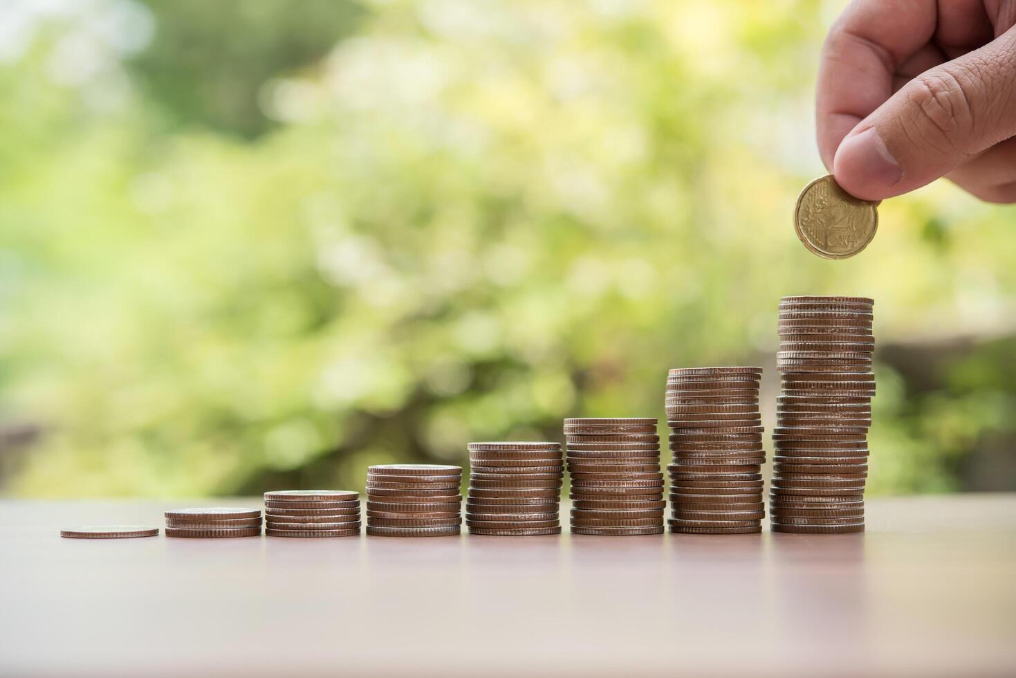 Geld sparen Konzept. Hand, die Geldmünzenstapel setzt foto