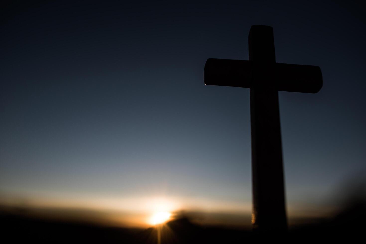 Silhouette des katholischen Kreuzes und des Sonnenaufgangs foto