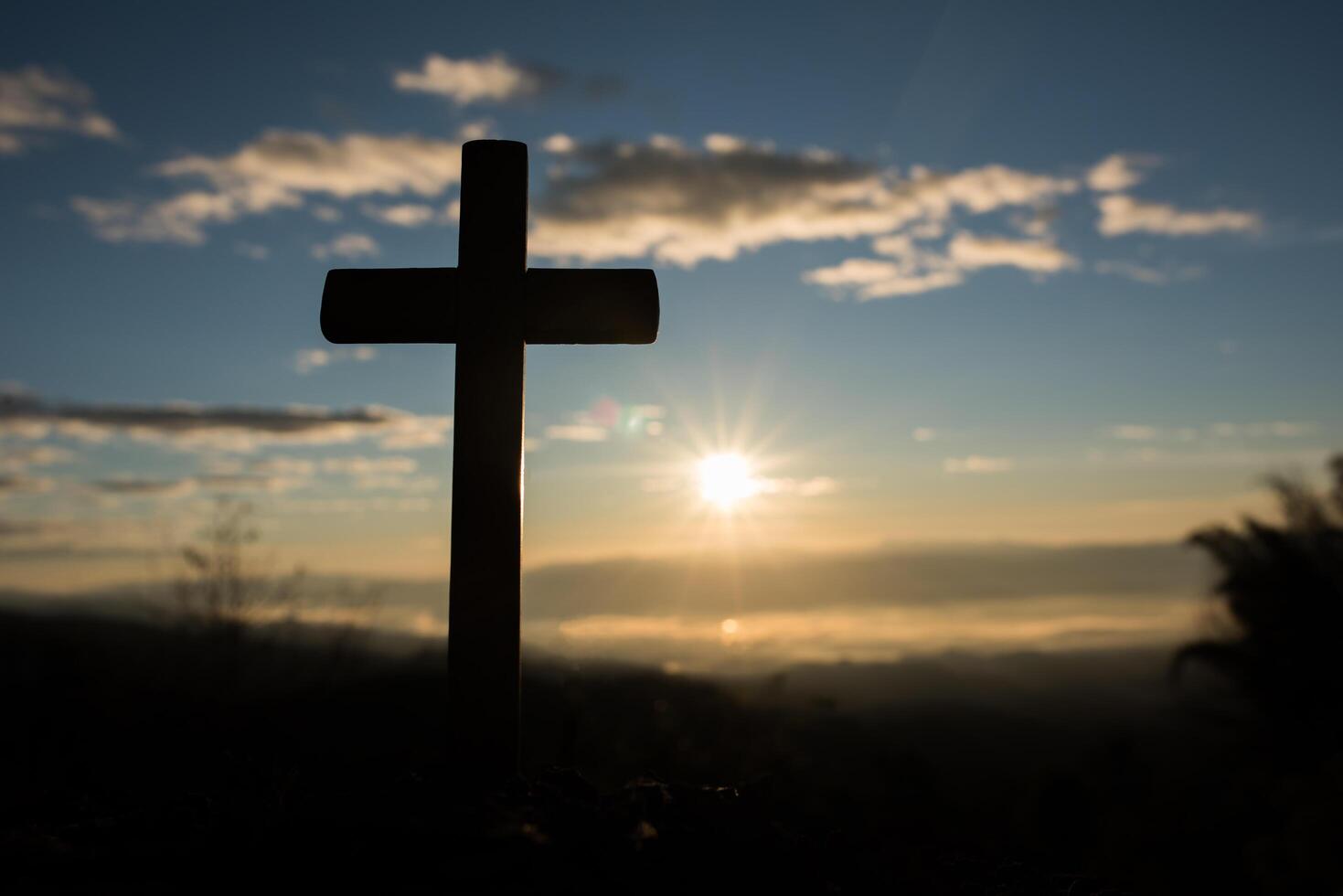 Silhouette des katholischen Kreuzes und des Sonnenaufgangs foto