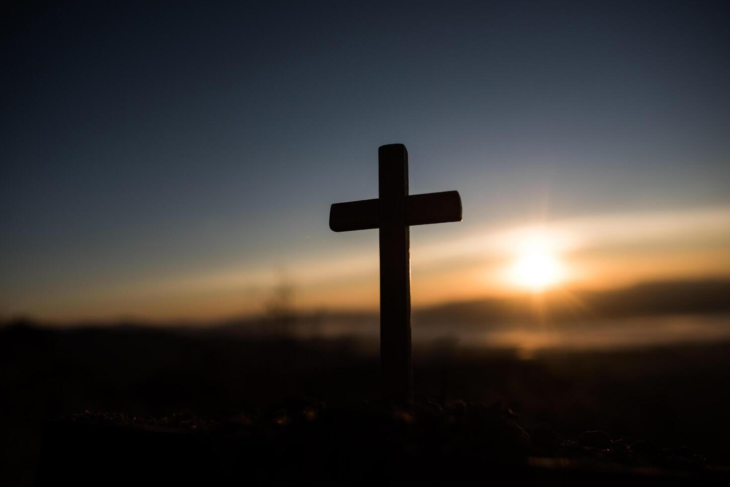 Silhouette des katholischen Kreuzes und des Sonnenaufgangs foto