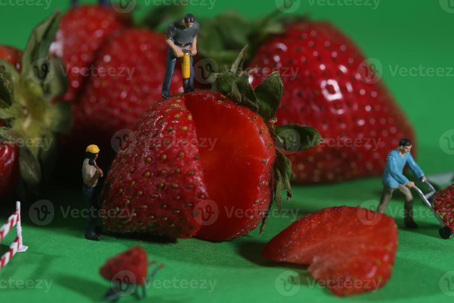 Bauarbeiter in konzeptionellen Essensbildern mit Erdbeeren foto