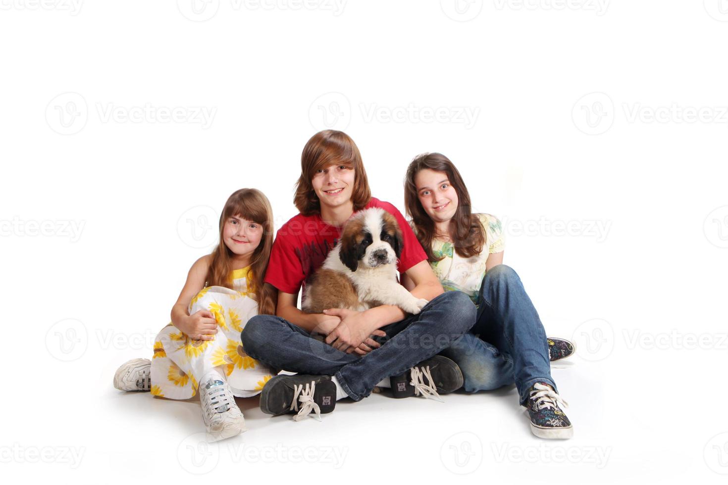 Geschwisterkinder mit ihrem neuen Bernhardinerwelpen foto