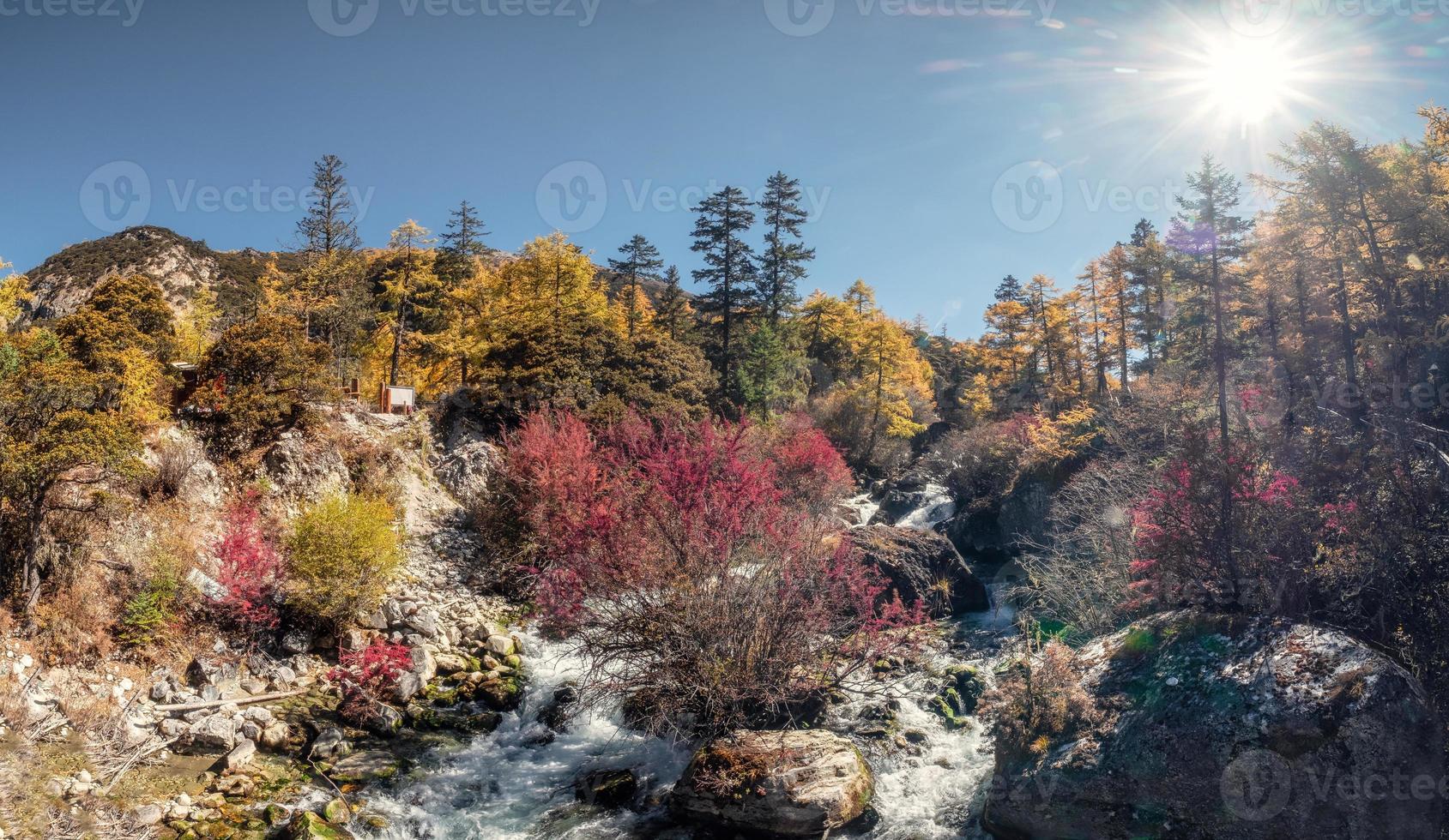 schöner Wasserfall im Herbstwald bei sonnigem foto