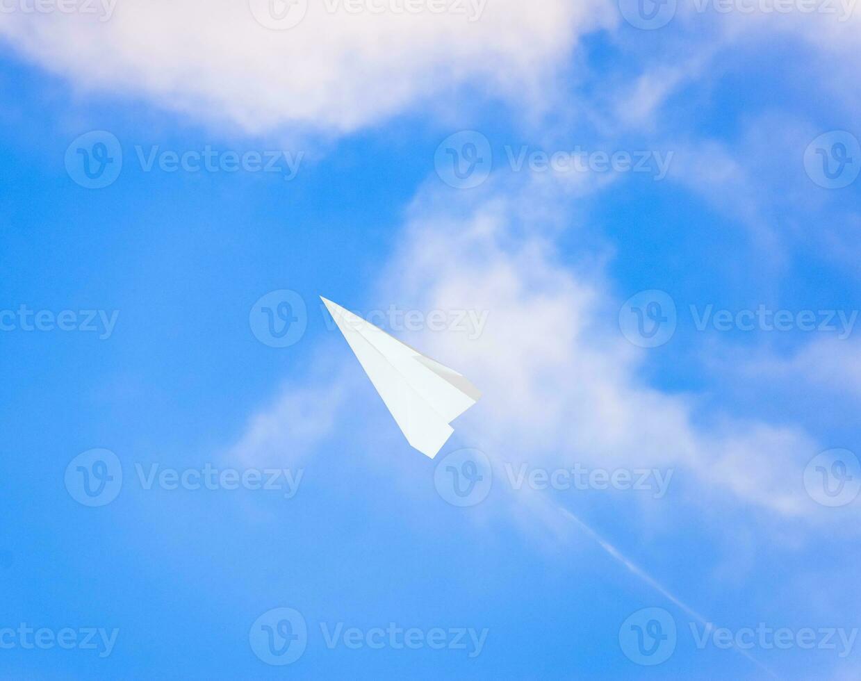 Weiß Papier Flugzeug im ein Blau Himmel mit Wolken. das Botschaft Symbol im das Bote foto