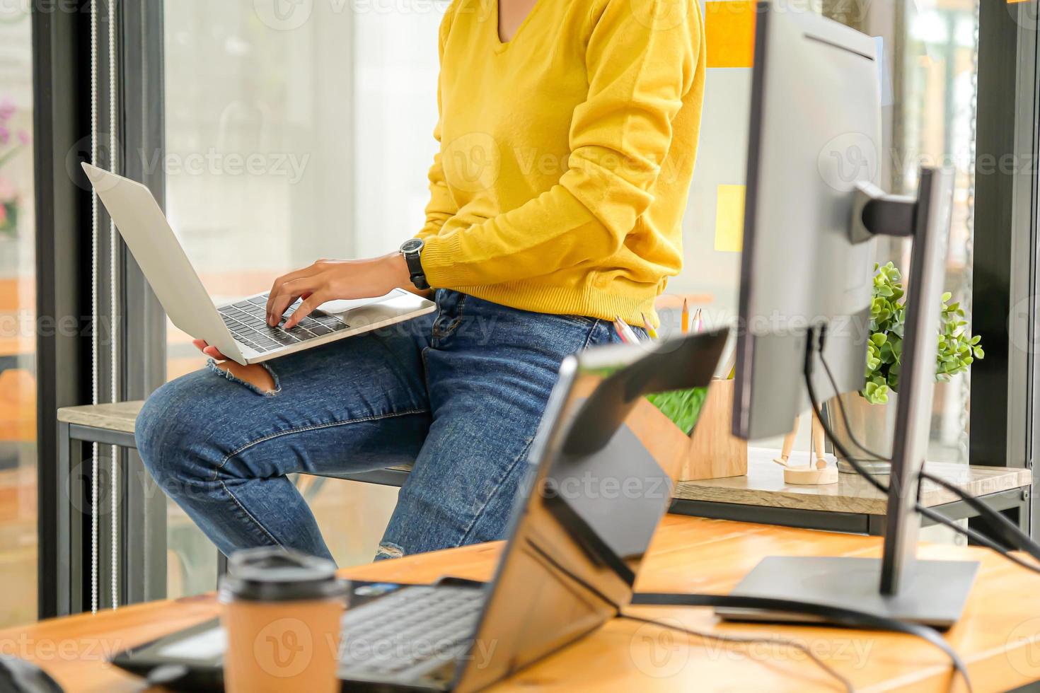 Programmierer verwenden Laptops, um das System im Büro zu testen. Sie legte den Laptop auf ihr Bein. foto