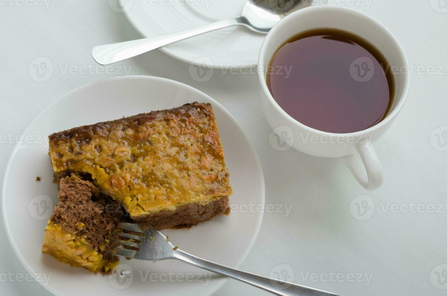 Karamell Erdnuss gekrönt Brownie Kuchen und ein Tasse von Tee foto