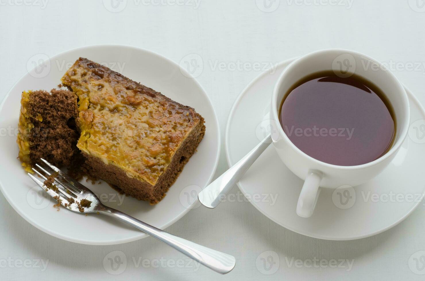 Karamell Erdnuss gekrönt Brownie Kuchen und ein Tasse von Tee foto