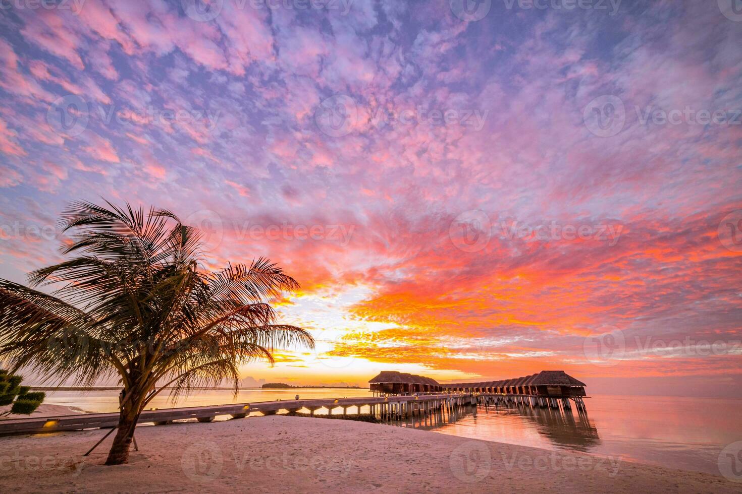 tolle Strandlandschaft. schöne Aussicht auf den Sonnenuntergang auf den Malediven. horizont bunte meer himmel wolken, über wasser villa pier weg. ruhige insellagune, tourismusreisehintergrund. exotischer Urlaub foto