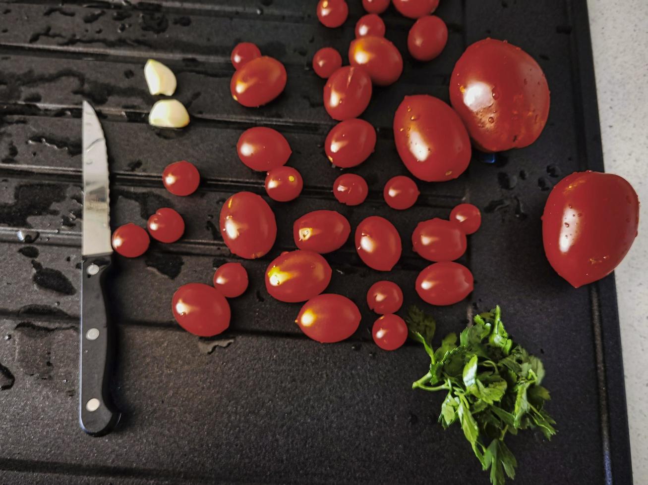 Kirschtomaten, Knoblauch und Petersilie in der italienischen Küche bereit zum Probieren und Essen foto