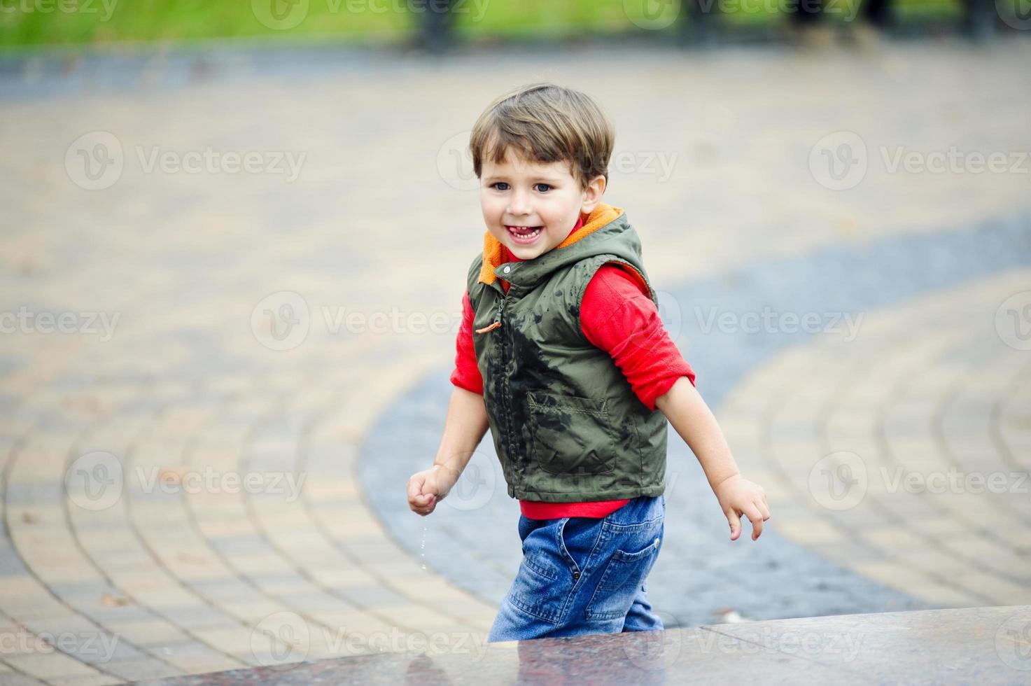 kleiner Junge, der auf Stadthintergrund mitspielt. foto