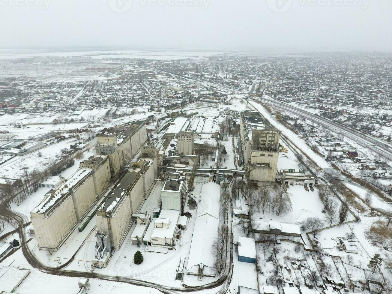 bestreut mit Schnee Korn Aufzug. Winter Aussicht von das alt Sowjet Aufzug. Winter Aussicht von das Vogel Auge Aussicht von das Dorf. das Straßen sind bedeckt mit Schnee foto