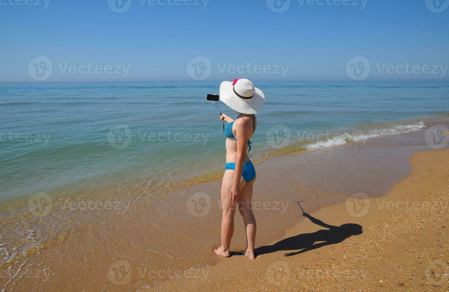 ein Mädchen mit ein Selfie Stock auf das Strand. Selfie auf das Strand foto
