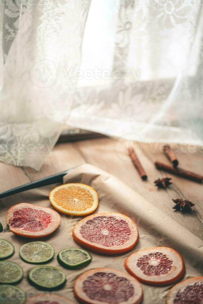 geschnitten orange, Mandarine und Grapefruit Scheiben auf Backen Blatt, vorbereiten Zitrusfrüchte Keile zum Weihnachten Girlande foto