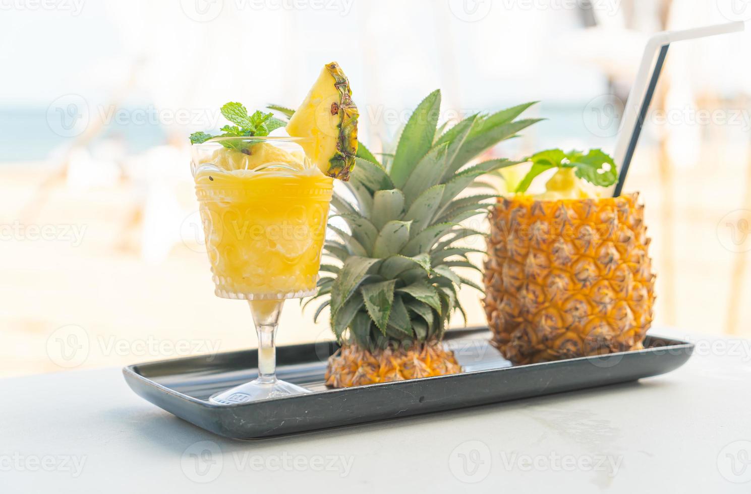 Ananas-Smoothies mit Meeresstrand-Hintergrund foto