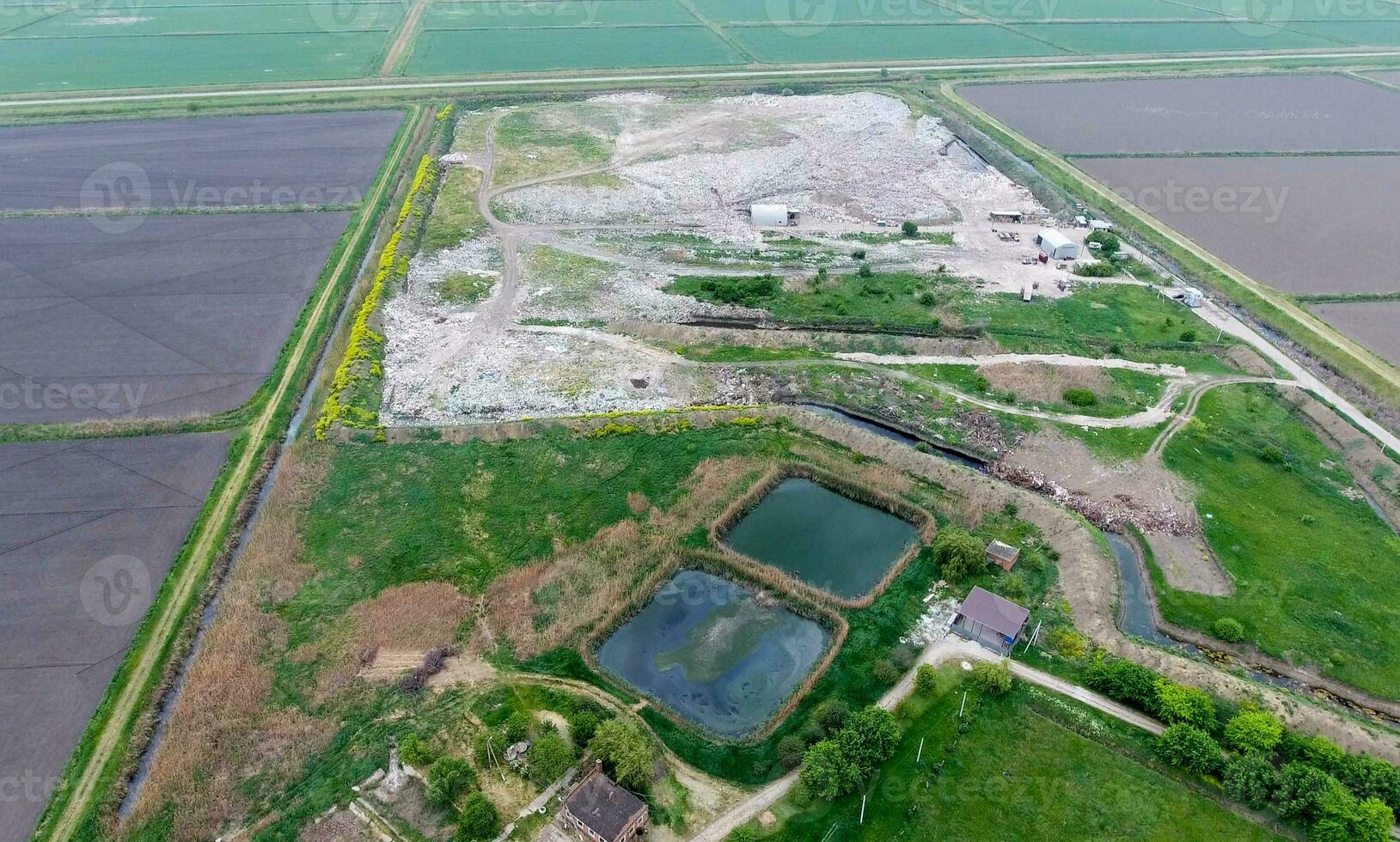 Müll Dump mit haufen von Müll und Behandlung Einrichtungen. Deponie von Müll draußen das Dorf foto