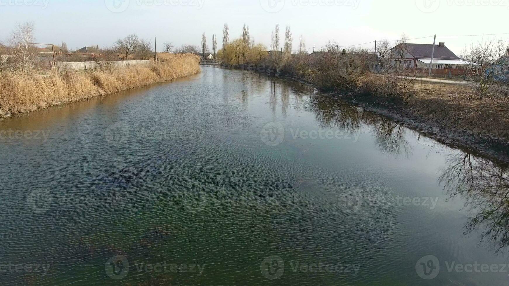 Fluss erik Strom im das Dorf im das Frühling. flach Fluss, langsam fließend im das Dorf. foto