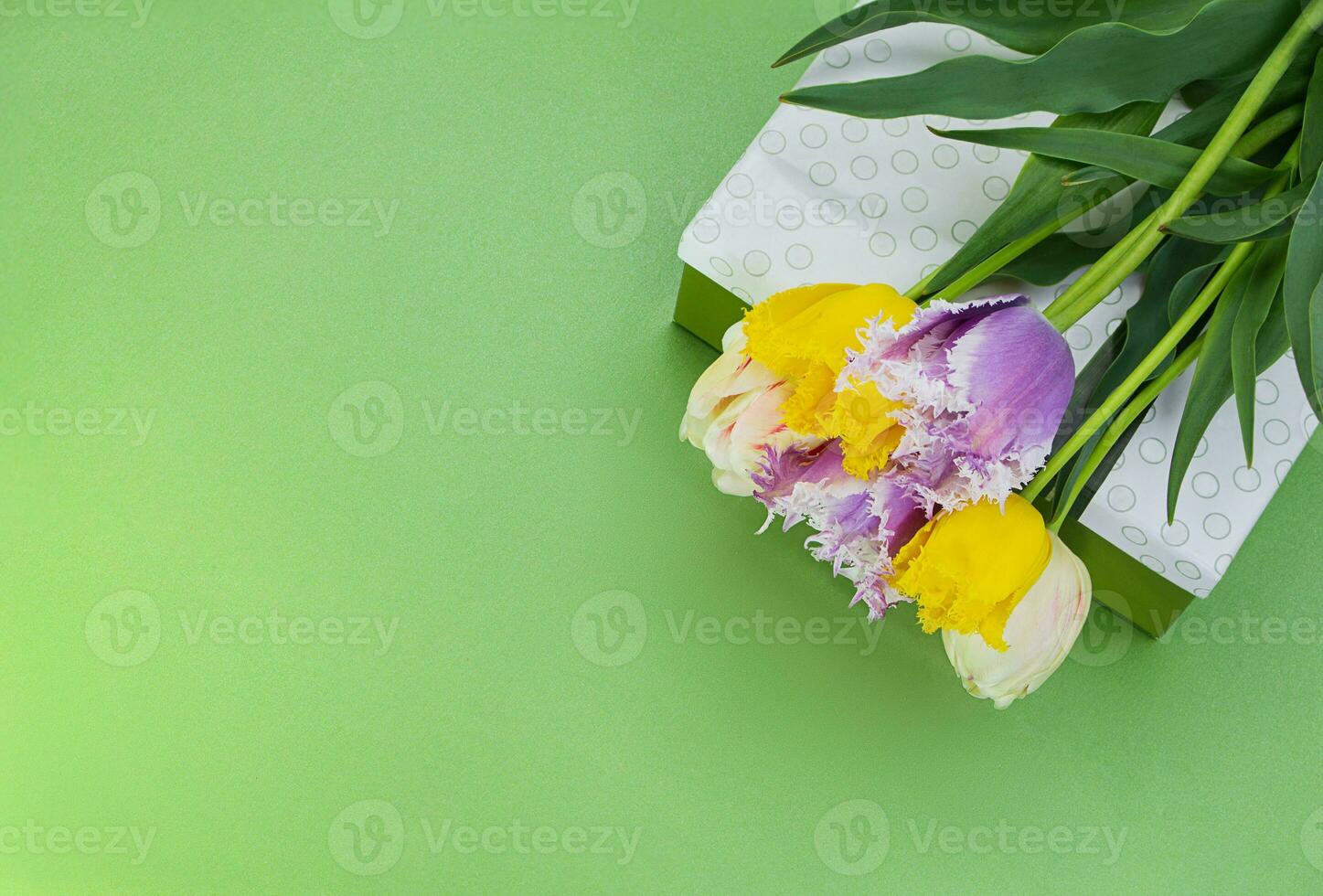 Strauß von mehrfarbig Tulpen auf Geschenk Box auf Grün Hintergrund. International Damen, Mutter, Valentinstag Tag, März 8, Geburtstag, Urlaub. Aussicht von über. Kopieren Raum foto