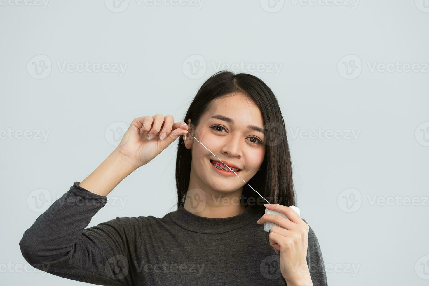 asiatisch Frau Hosenträger mit Dental Zahnseide. Zähne Hosenträger auf das Weiß Zähne von Frauen zu ausgleichen das Zähne. Halterung System im lächelnd Mund, schließen oben Foto Zähne, Makro Schuss, Zahnarzt Gesundheit Konzept.