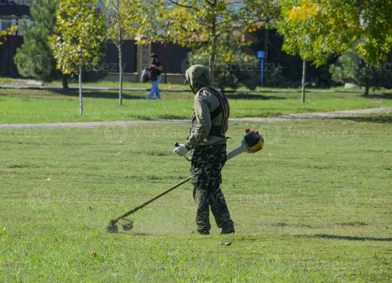 Arbeiter Mähen Gras mit ein Benzin Bürste. Trimmer. foto