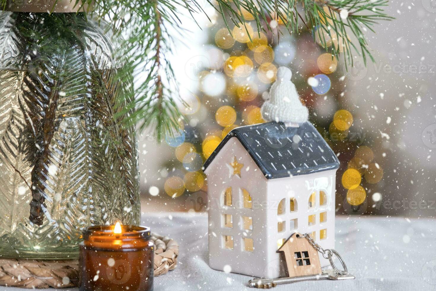 Schlüssel und winzig Haus von ein klein Größe auf gemütlich Zuhause mit Weihnachten Dekor auf Tabelle von festlich Küche. Geschenk zum Neu Jahr. Versicherung, ziehen um zu Neu Haus, Hypothek, Miete und Kauf echt Nachlass foto