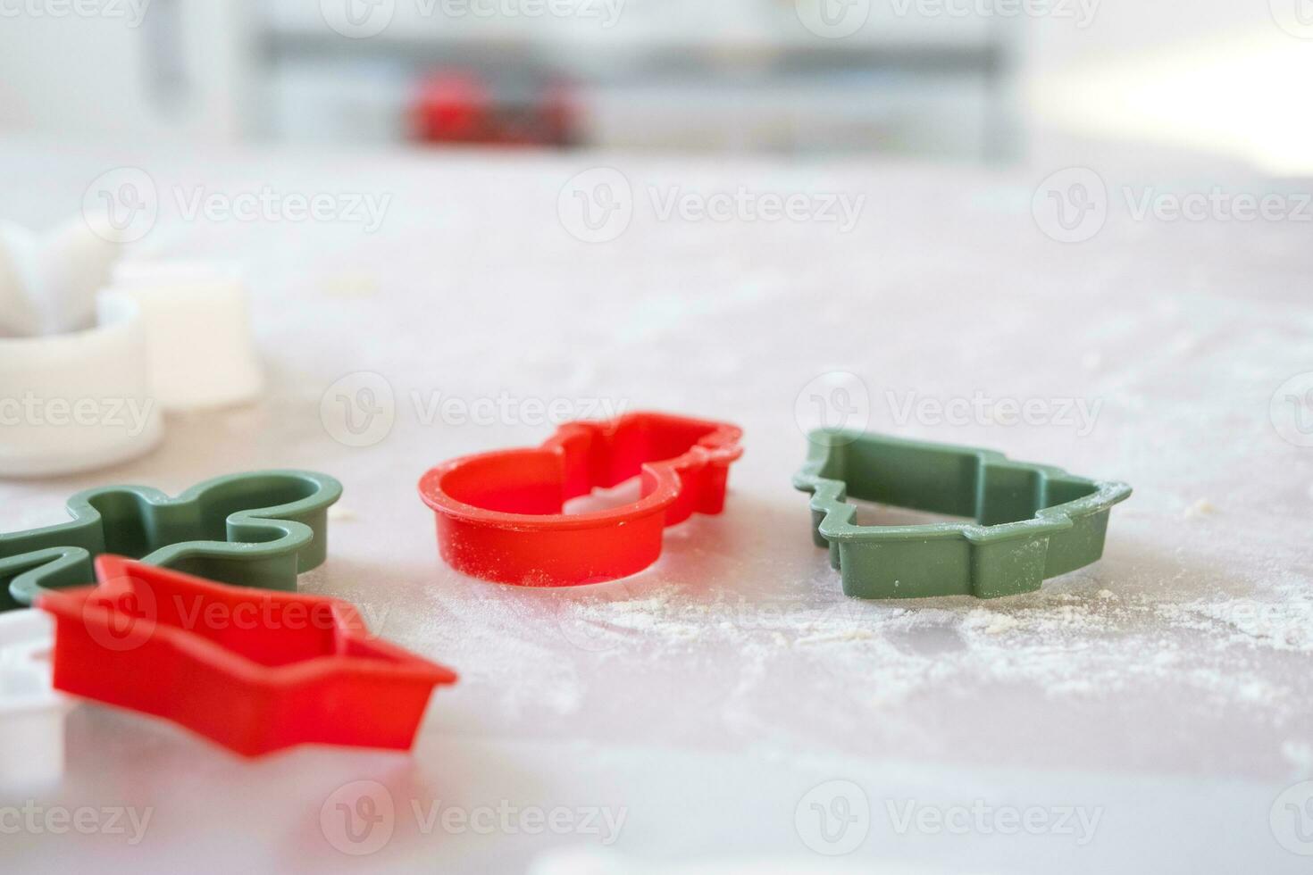 Layout von Plätzchen Schneider Nahansicht Schnitt aus Kekse von das Teig mit Formen auf ein Weihnachten Thema im das bilden von ein Schneemann, ein Weihnachten Baum, Sterne im das Küche foto