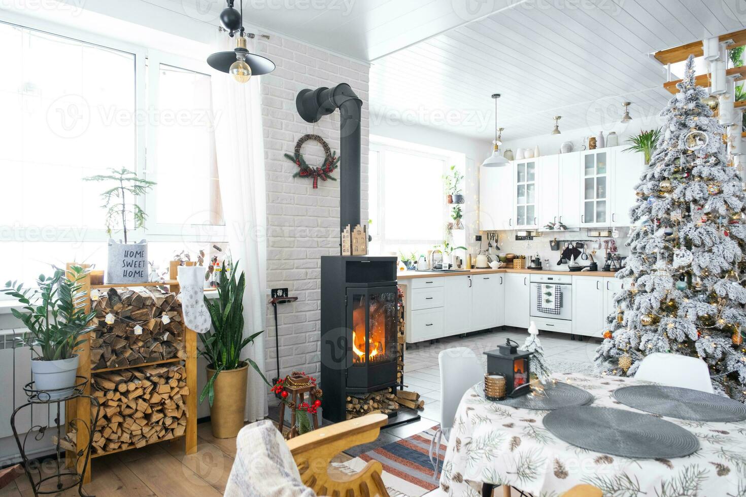 Weihnachten Dekor im Weiß Küche mit Verbrennung Herd Kamin, festlich Durcheinander, Dorf Innere mit ein schneebedeckt Weihnachten Baum. Neu Jahr, Weihnachten Stimmung, gemütlich heim. foto