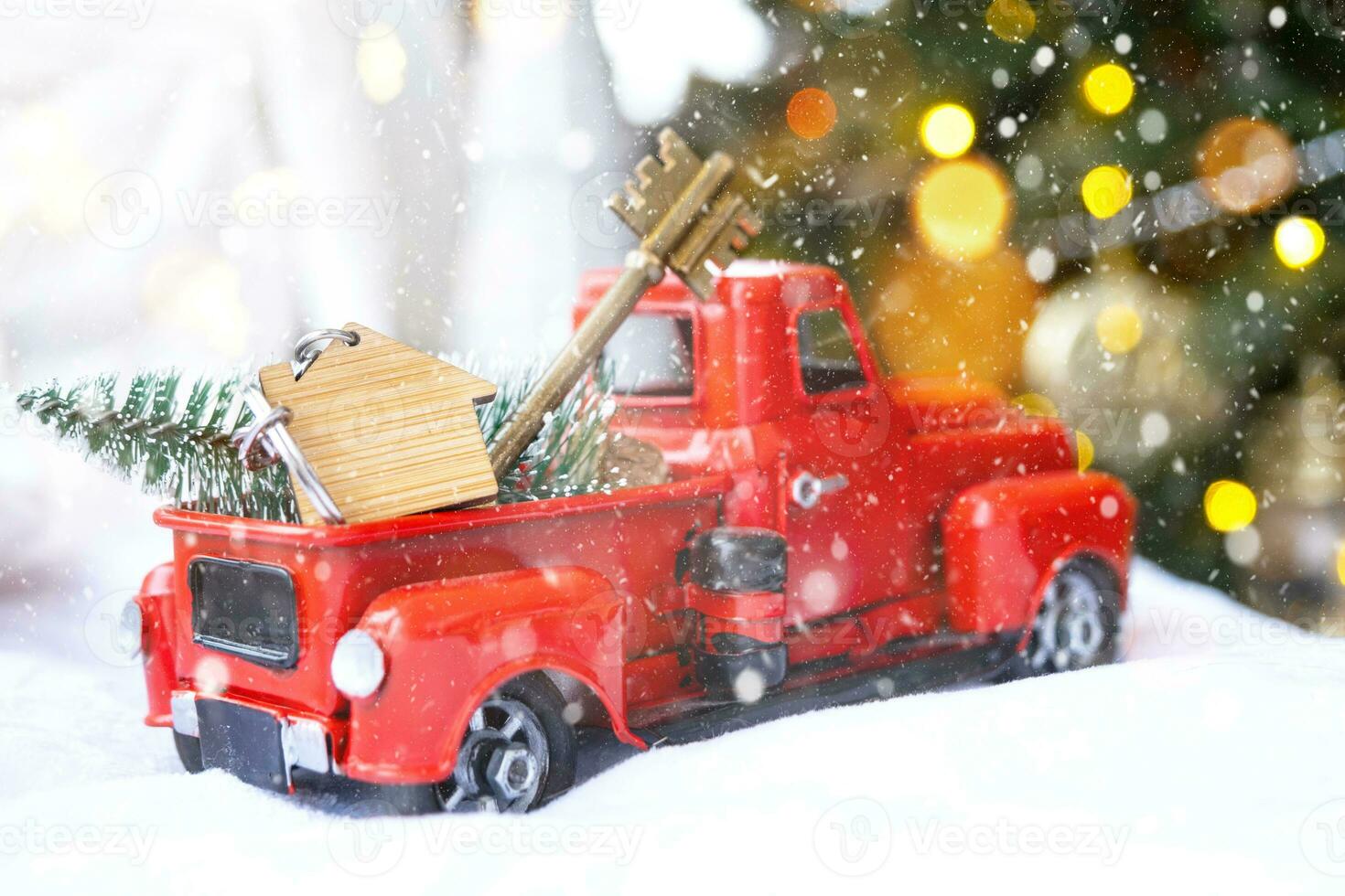 Rotes Retro-Auto mit einem Weihnachtsbaum schmückt mit dem Hausschlüssel im Pickup-Truck zu Weihnachten. Hauskauf, Umzug, Hypothek, Darlehen, Immobilien, Feststimmung, Neujahr foto