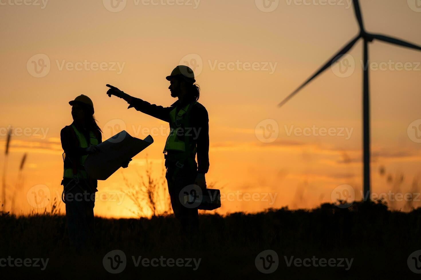 Silhouette von Ingenieur im aufladen von Wind Energie gegen ein Hintergrund von Wind Turbinen. foto