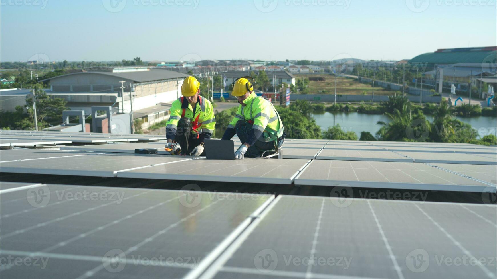 beide von Techniker ist Installation Solar- Paneele auf das Dach von das Warenhaus zu Veränderung Solar- Energie in elektrisch Energie zum verwenden im Fabriken. foto