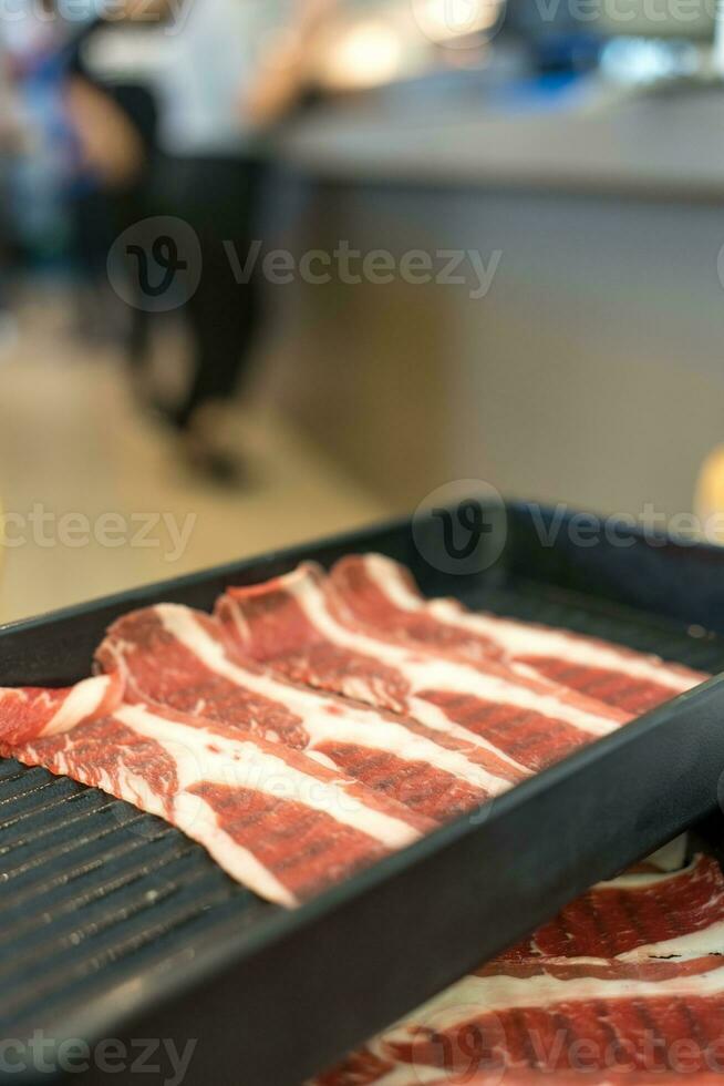 Prämie Rindfleisch Scheibe auf schwarz Tablett zum heiß Topf oder Grill. foto