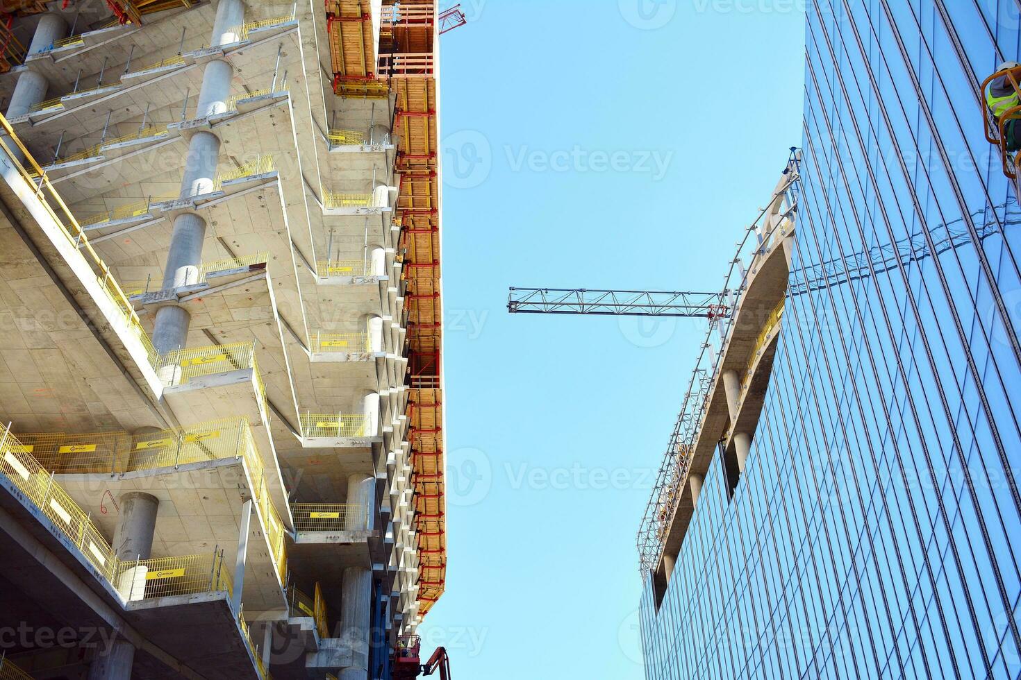 hoch erhebt euch Gebäude unter Konstruktion. Installation von Glas Fassade Paneele auf ein verstärkt Beton Struktur. foto