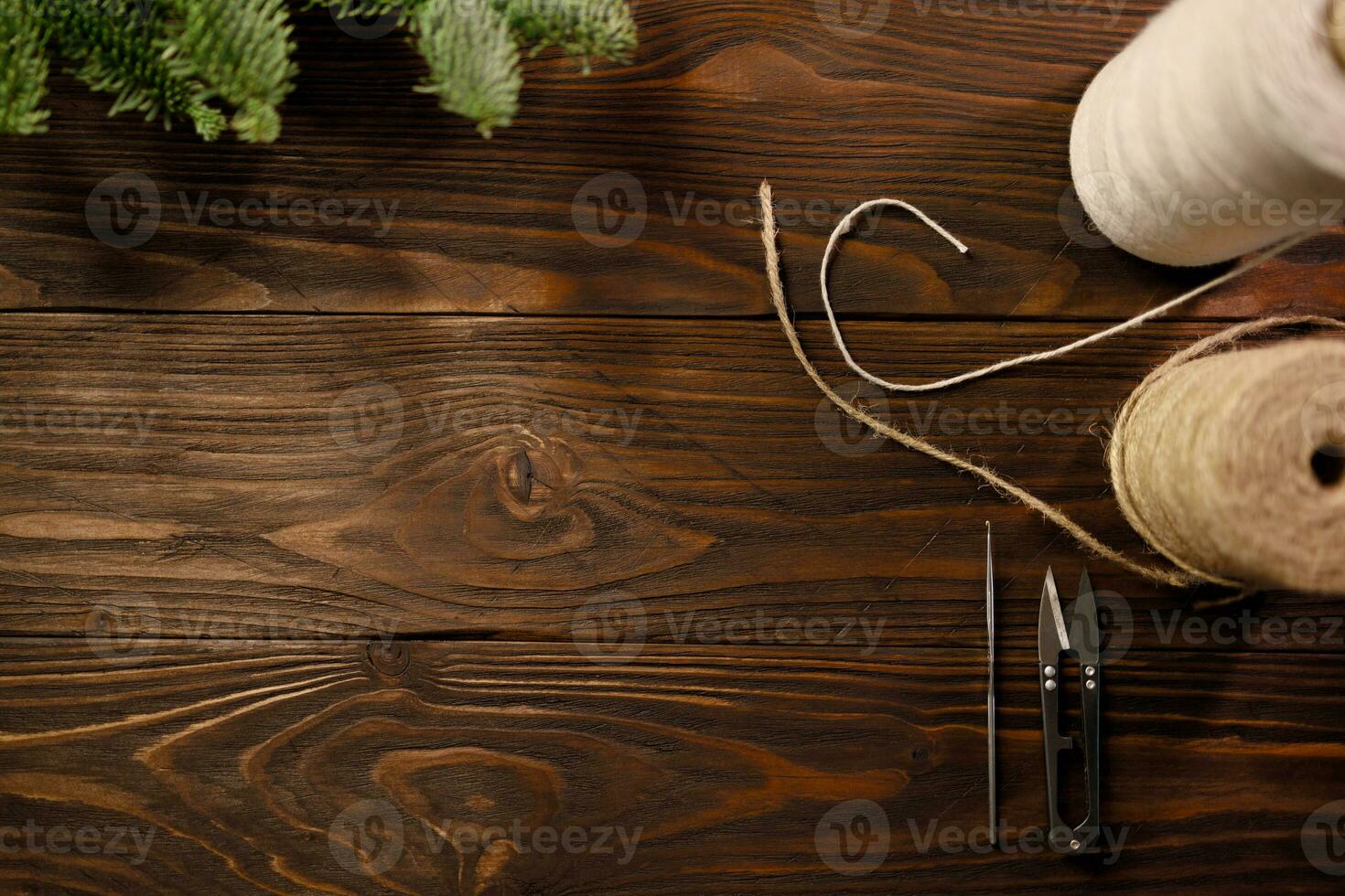 häkeln Haken, Schere, verdrehte Baumwolle Seil und Sackleinen Kabel auf hölzern Tabelle dekoriert mit Fichte Geäst foto