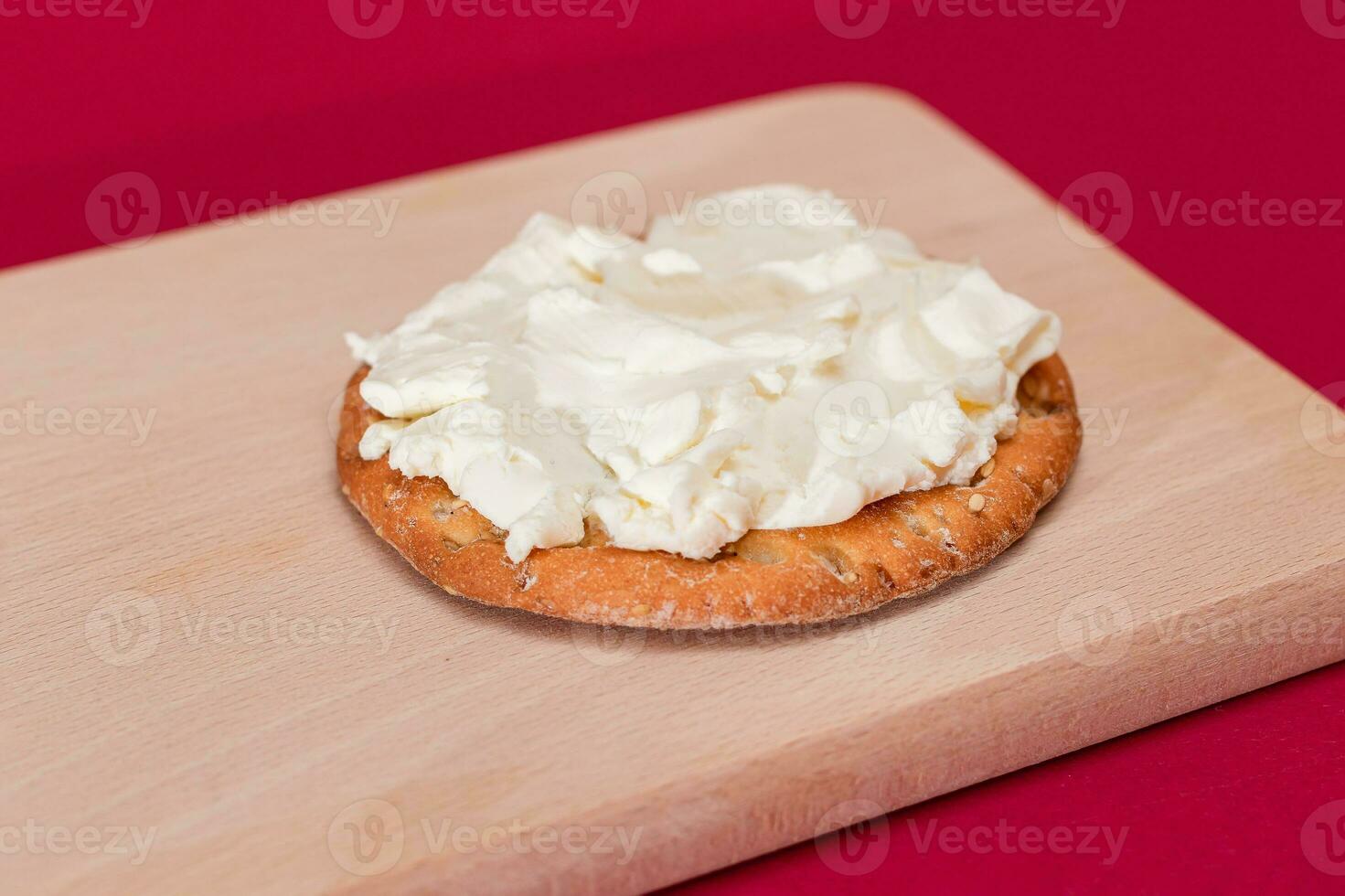 knusprig Cracker Sandwich mit Sahne Käse auf hölzern Kochen Tafel auf Magenta Hintergrund foto