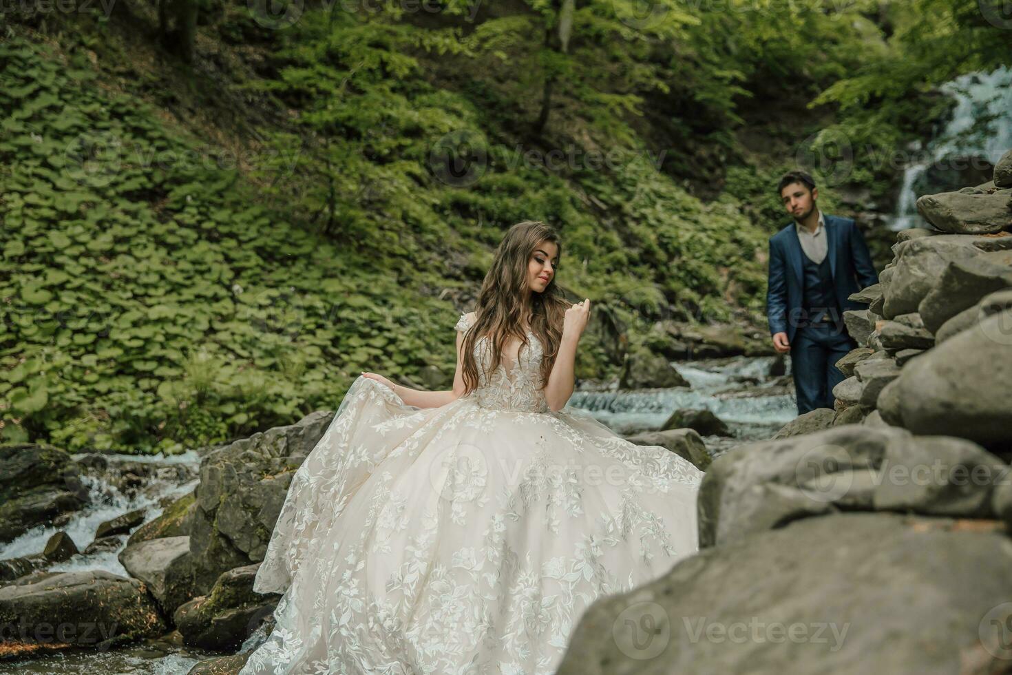 Hochzeit Paar in der Nähe von ein Berg Fluss. sie ist im das Vordergrund im Fokus. Bräutigam und Braut. Hochzeit Foto Session im Natur. Foto Session im das Wald von das Braut und Bräutigam.