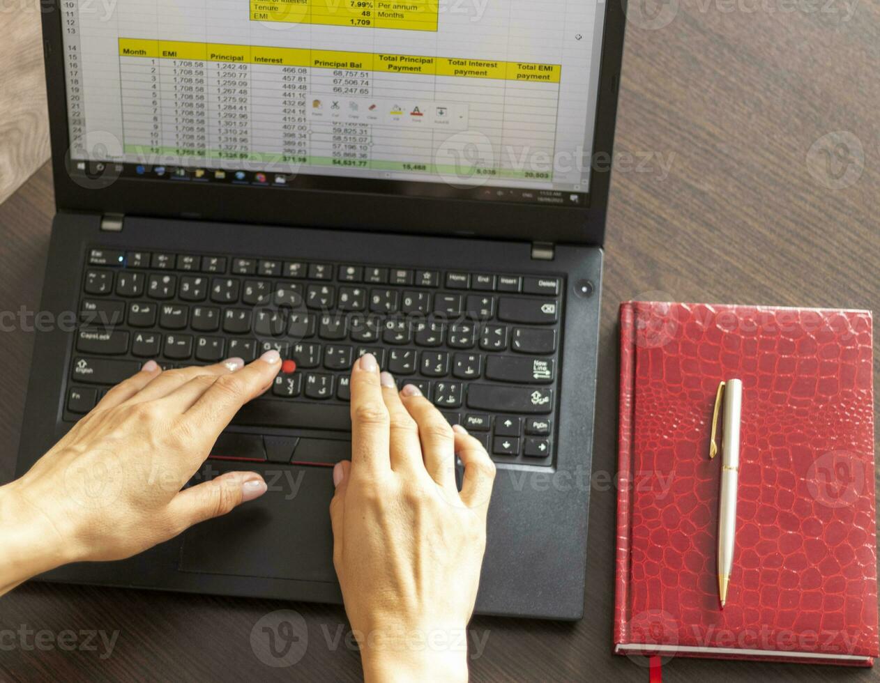 Schuss von ein Frau Arbeiten auf das Laptop zeigen ein übertreffen Blatt auf das Bildschirm mit Bank Darlehen Amortisation Tisch. Buchhaltung foto
