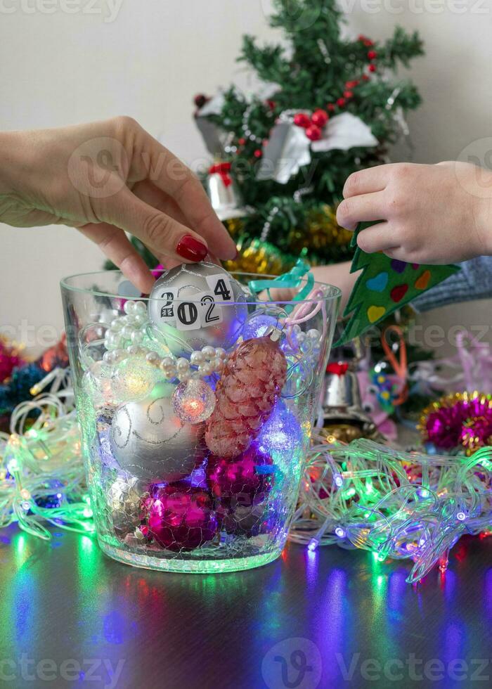 schließen oben Schuss von Frau und wenig Junge dekorieren Weihnachten Baum. Neu Jahr Ändern Zahlen. Urlaub foto