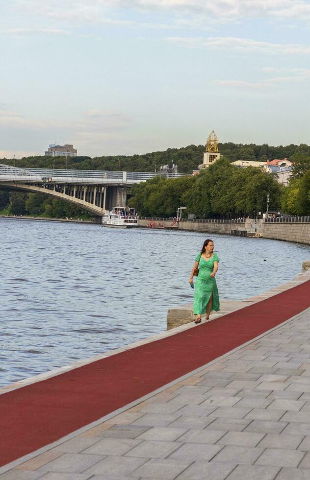 Moskau, Russland - - 30.07.2023 - - Frau im Grün Kleid Gehen im das Park. draußen foto