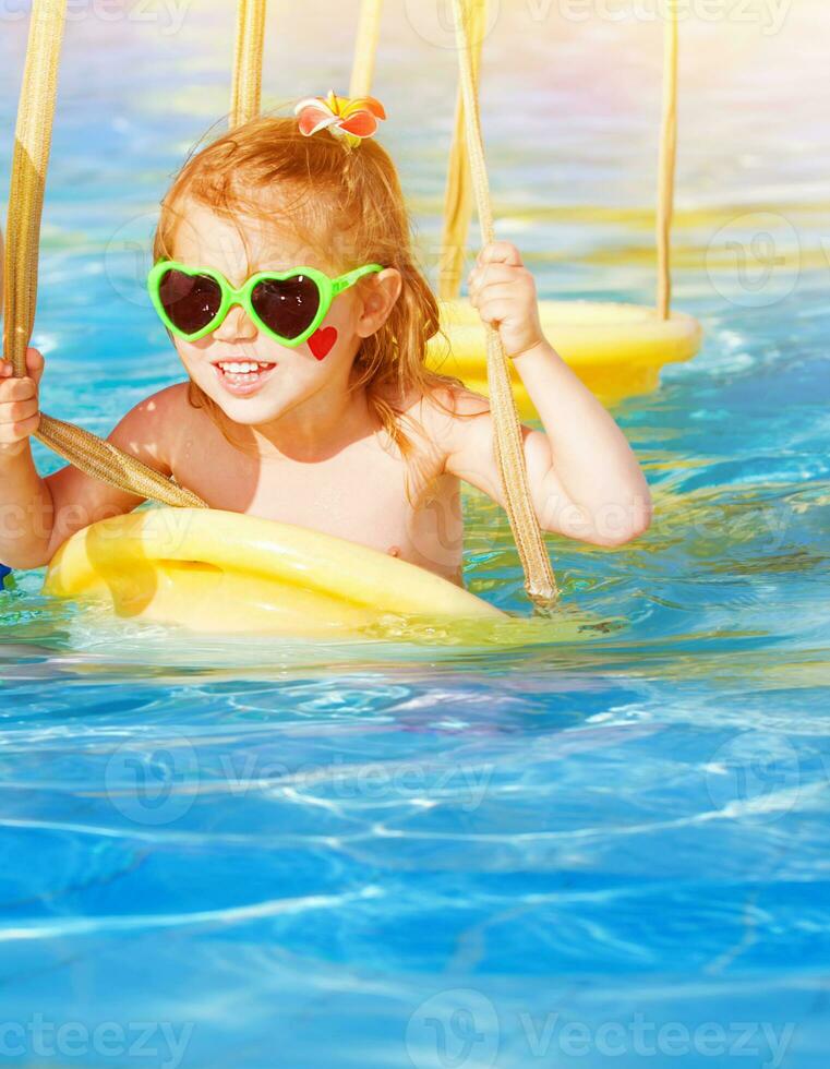 wenig Mädchen auf Wasser schwingen foto