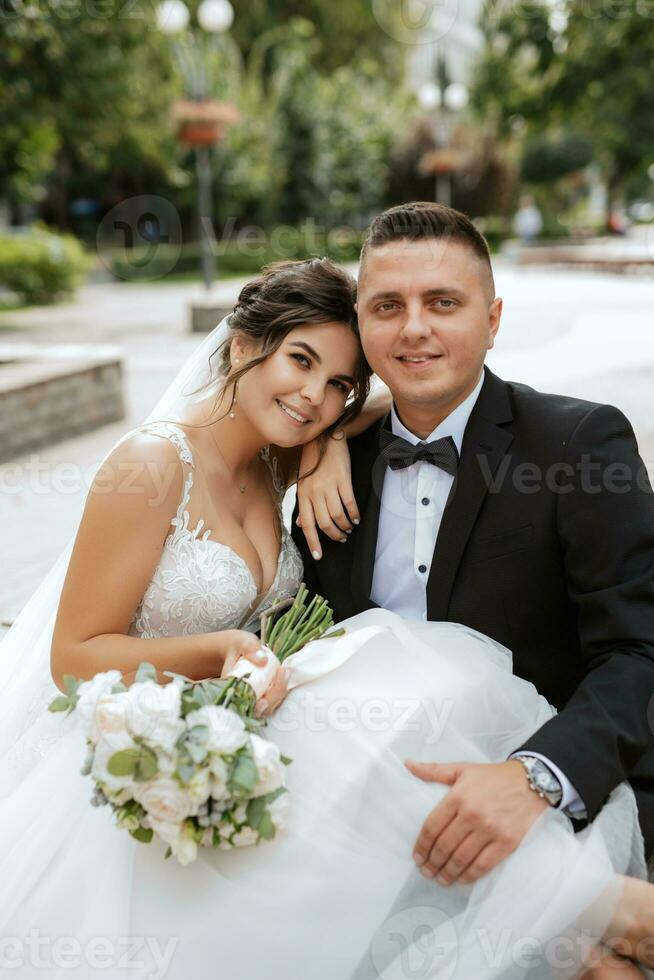der Bräutigam im braunen Anzug und die Braut im weißen Kleid foto