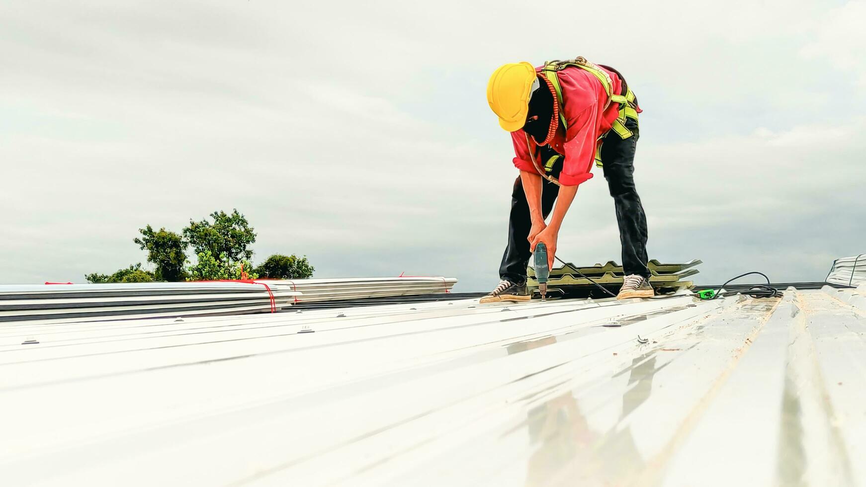 Konstruktion Arbeiter Installieren Dach, Überdachung Werkzeug, Arbeit mit elektrisch bohren Ersatz Installieren Dach Dach Platten. foto