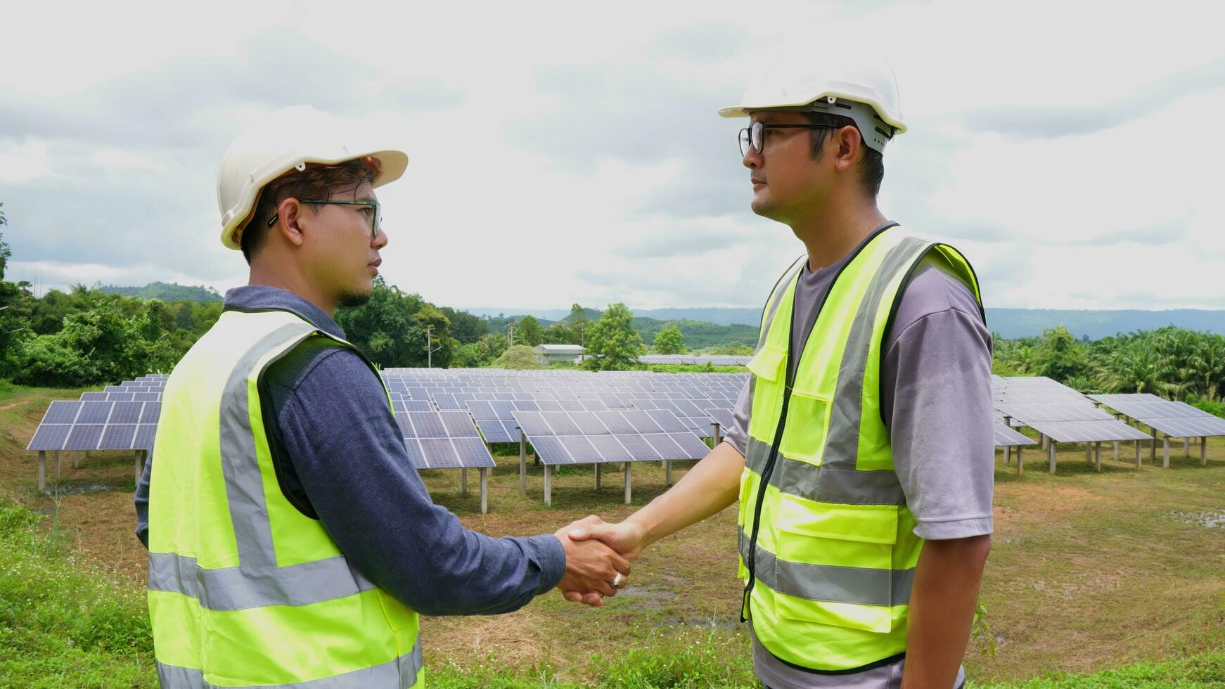 zwei asiatisch Ingenieure zittern Hände nach Installation Solar- Paneele . Solar- Energie sauber und Grün Alternative Energie. Einheit und Zusammenarbeit. foto