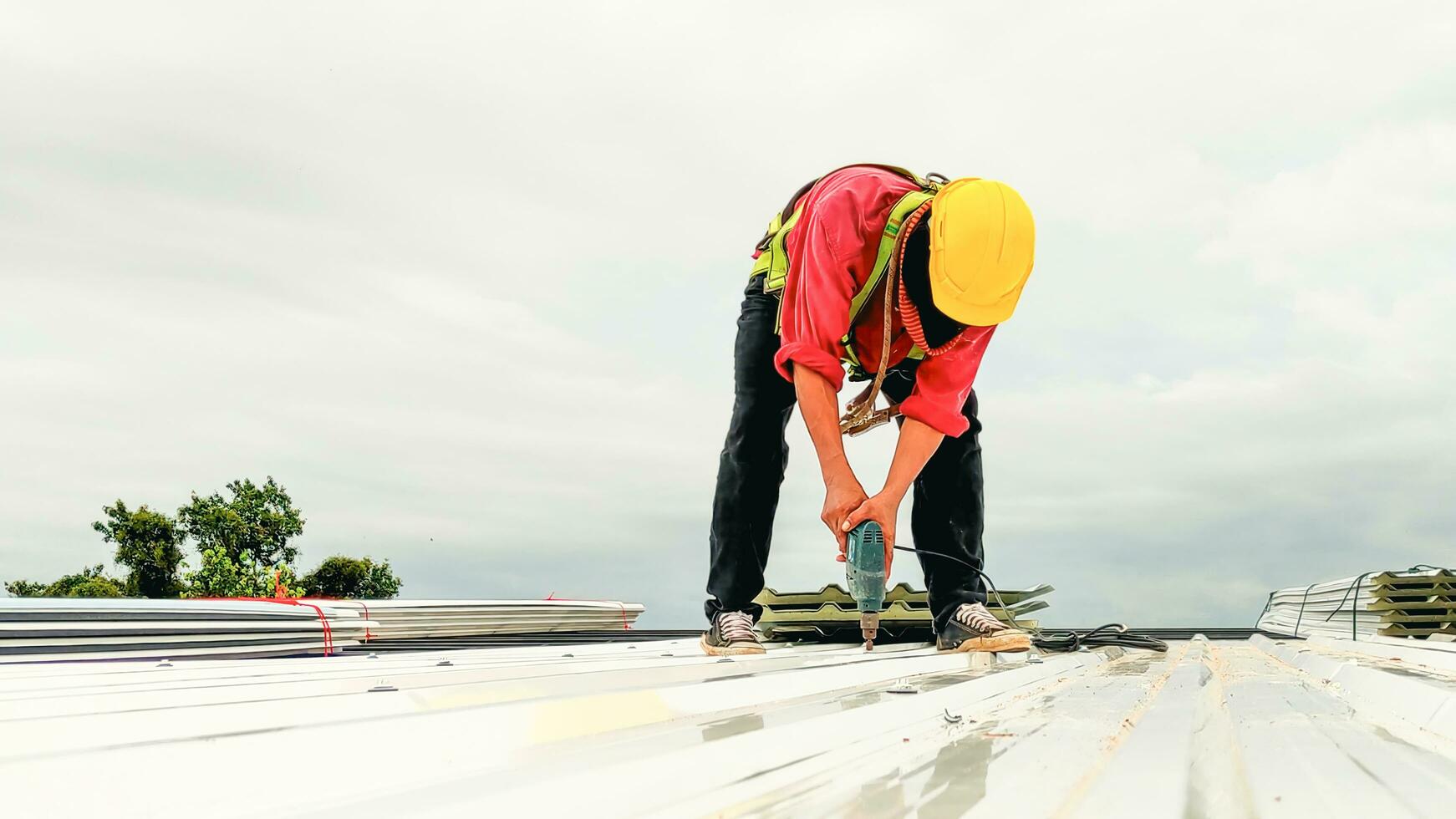 Konstruktion Arbeiter Installieren Dach, Überdachung Werkzeug, Arbeit mit elektrisch bohren Ersatz Installieren Dach Dach Platten. foto