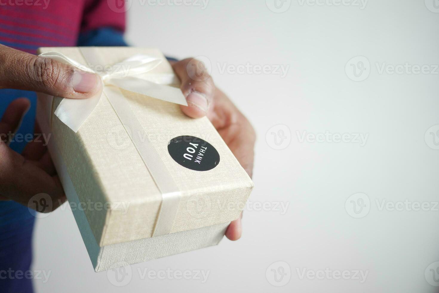 Hand Putten ein danken Sie Aufkleber auf ein Geschenk Box foto