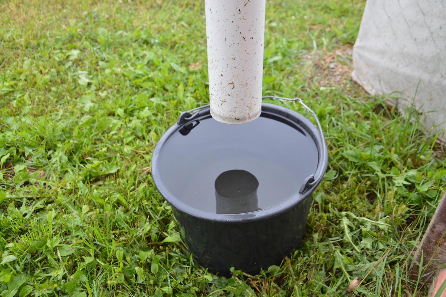 Wasser tropft nach Regen in den Eimer foto