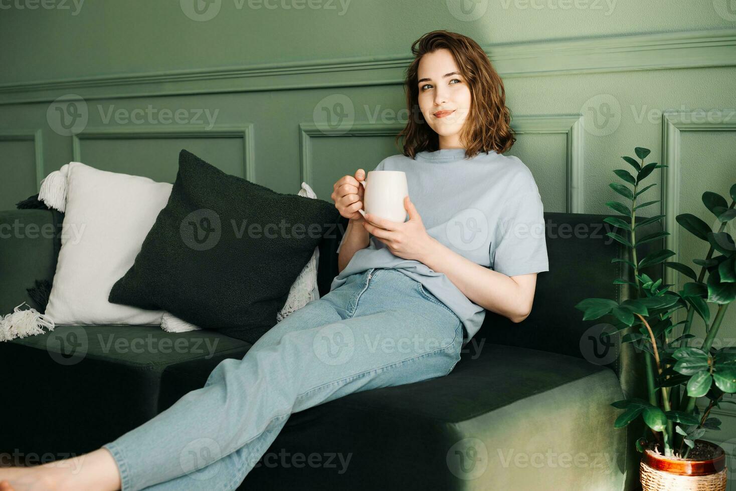 entspannt jung Frau reflektieren mit Tee Kaffee im Zuhause Einstellung. heiter Stimmung und Selbstbeobachtung im gemütlich Innen- Ambiente. zuversichtlich Einsamkeit und friedlich Haltung im still Umfeld. foto